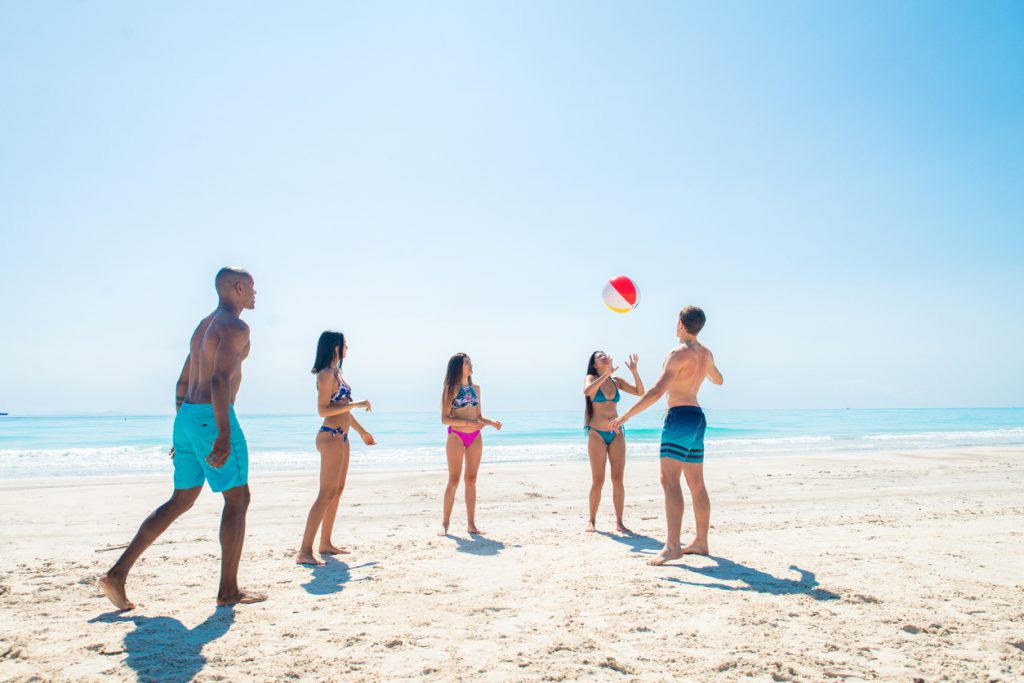 Group of friends having fun on the beach - Young and happy tourists bonding outdoors, enjoying summertime